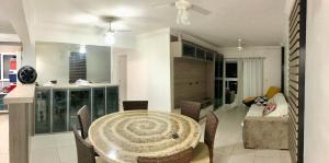 a dining room and kitchen with a table and chairs at Spazio Felicita, Indaia, Bertioga, apartamento pé na areia in Bertioga +2 photos