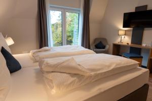 2 Betten in einem Hotelzimmer mit Fenster in der Unterkunft Hotel-Landgasthaus Ständenhof in Ruppertsweiler