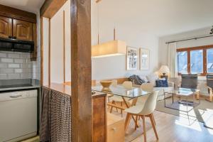 Naut AranにあるLuderna - Apartamento Tanau A1 Esquirósのテーブルと椅子のあるキッチンとリビングルーム