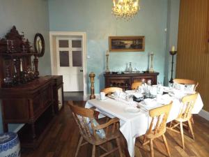 uma sala de jantar com uma mesa branca e cadeiras em Old Vicarage B&B em Coleford