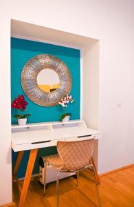 a desk with a mirror and a chair in a room at Backpacker Apartment Hofburg in Vienna