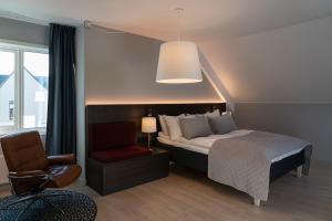 a bedroom with a bed and a chair and a lamp at Quality Hotel Ålesund in Ålesund