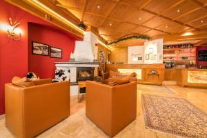 a living room with brown chairs and a fireplace at Hotel-Appartement Ferienhof in Gerlos