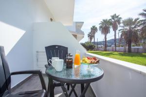 a table with a bowl of fruit and drinks on a balcony at Rosie's Bellezza in Faliraki