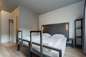 ein Schlafzimmer mit einem großen Bett mit weißen Laken und Kissen in der Unterkunft a&o Köln Dom in Köln