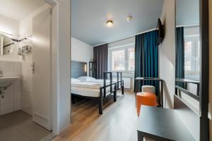 ein Hotelzimmer mit einem Bett und einem Badezimmer in der Unterkunft a&o Köln Dom in Köln