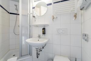 ein weißes Badezimmer mit Waschbecken und Toilette in der Unterkunft a&o Köln Dom in Köln