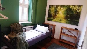 リューネブルクにあるフェリエンヴォーヌング アン デア ニコライキルヒェのベッド付きの小さな部屋で、壁には絵画が飾られています。