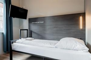 ein Bett mit weißen Laken und Kissen darauf in der Unterkunft a&o Köln Dom in Köln + 18 Fotos