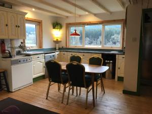 a kitchen with a table and chairs in it at Beautiful Highland 1-Bed Cottage in Inverness