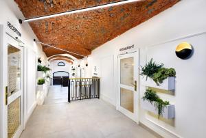 un corridoio con pareti bianche e un soffitto di mattoni di Kalix Boutique Hotel a Poprad