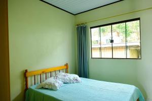 a bedroom with a bed with a pillow and a window at Apartamento primeiro andar in Garopaba