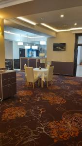 Hotel Story في تارغو جيو: غرفة طعام مع طاولة وكراسي في غرفة