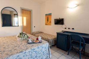 una camera d'albergo con un letto e un tavolo con cibo sopra di Hotel il Delfino a San Vincenzo