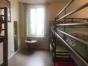 巴黎的住宿－Art Beaubourg，客房设有两张双层床、一张桌子和一扇窗户。