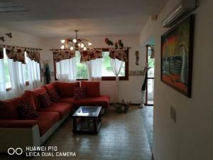 sala de estar con sofá rojo y mesa en Edificio Maracuja - Departamentos en Villa Gesell