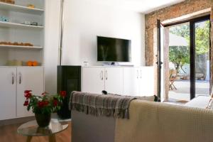 a living room with a couch and a tv at Casas do Torreão 3 casas de alojamento local in Alfaiates