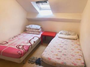 two beds in a small room with a window at Art Beaubourg in Paris