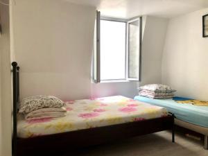a small bedroom with a bed and a window at Art Beaubourg in Paris