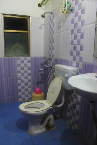 a bathroom with a toilet and a sink at HOTEL PARK LAGOON in Puri