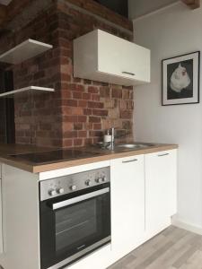 a kitchen with white appliances and a brick wall at Martins Guesthouse Zimmer in Hannover