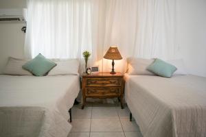 um quarto com duas camas e uma mesa com um candeeiro em Boho Studio in Little Havana - 5K em Miami