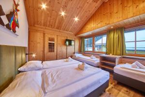 1 Schlafzimmer mit 3 Betten in einem Zimmer mit Holzdecken in der Unterkunft Holiday Home Viehhofen in Viehhofen