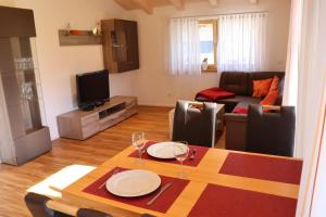 a living room with a table and a couch at Ferienwohnung Bichelblick in Hopferau