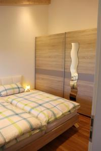 Un dormitorio con una cama con cabecero de madera. en Ferienwohnung Breyer Wiedemen, en Hopferau