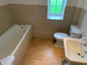 a bathroom with a tub and a toilet and a sink at The Coppleridge Inn in Motcombe