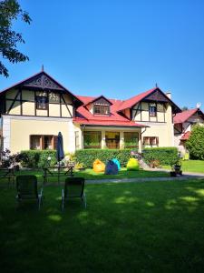 a house with chairs in the grass in front of it at Penzión Pod orechom in Turčianske Teplice