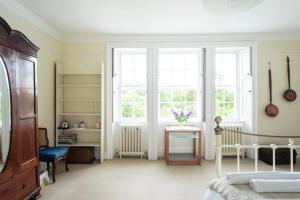 a bedroom with a bed and a desk and windows at Percy Place Bath in Bath