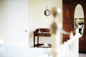 een kamer met een houten bureau en een spiegel bij Percy Place Bath in Bath +29 foto's