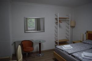 a bedroom with a bed and a table and a chair at Gasthof Bittner in Meinerzhagen