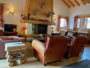 a living room with leather furniture and a fireplace at Chalet Roseau in Megève