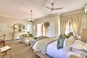 a bedroom with a large bed and a living room at Fernwood Manor Boutique Guest House in Cape Town +39 photos