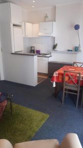 a small kitchen with a table and a red table cloth at Apartment Van Hecke in Blankenberge