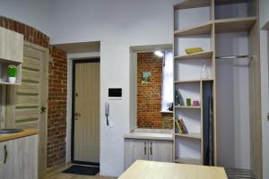 a kitchen with a table and a brick wall at Aquamarine apartments Lviv in Lviv
