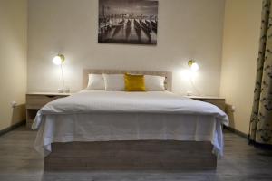 1 dormitorio con 1 cama grande y 2 lámparas a ambos lados en Aquamarine apartments Lviv en Leópolis