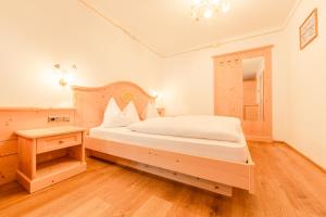 una camera con un grande letto e un tavolo di Residence Grüne Laterne - Lanterna Verde a Sesto