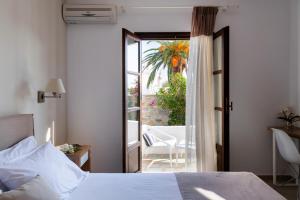 una camera con letto e porta di accesso a un patio di Aella Residence a Naoussa