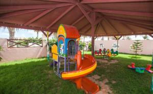 un parque infantil con un equipo de juegos en el césped en Hotel & Club Lella Meriam, en Zarzis