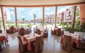 ein Restaurant mit Tischen und Stühlen und einem großen Fenster in der Unterkunft Hotel & Club Lella Meriam in Zarzis