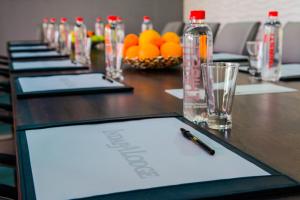 a long wooden table with a pen and bottles on it at Indaba Lodge Hotel Richards Bay in Richards Bay +44 photos