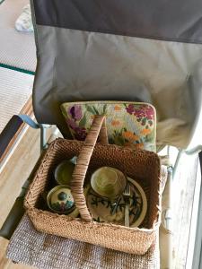 a basket filled with dishes and a bag on a chair at Travelers House おーさんてぃん青空舎 in Taketomi