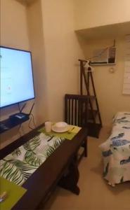 a room with a desk with a computer monitor and a bed at Affordable and Comfortable Serin East Tagaytay Condominun in Tagaytay