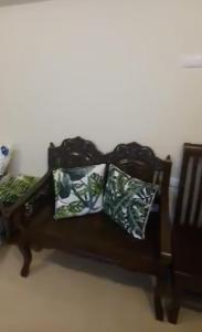 a brown couch with two pillows on it at Affordable and Comfortable Serin East Tagaytay Condominun in Tagaytay