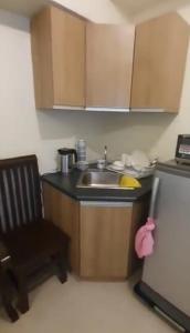 a small kitchen with a sink and a chair at Affordable and Comfortable Serin East Tagaytay Condominun in Tagaytay