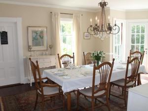 uma sala de jantar com uma mesa branca e cadeiras em The Beech Tree B&B em Rockport