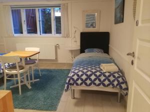 a small bedroom with a bed and a table at Royaltybed Copenhagen in Copenhagen